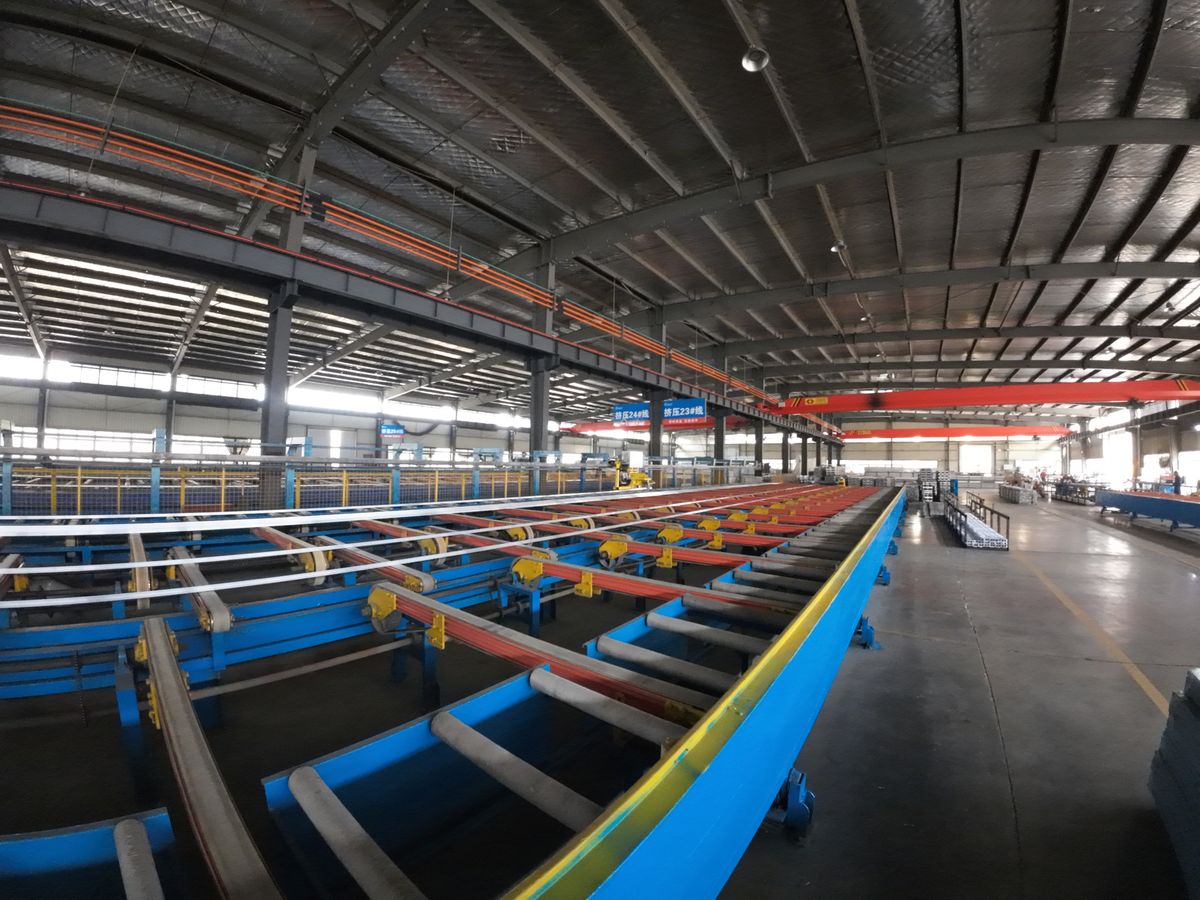 Extrusion cooling line where freshly extruded aluminum battery box profiles are cooled and straightened.